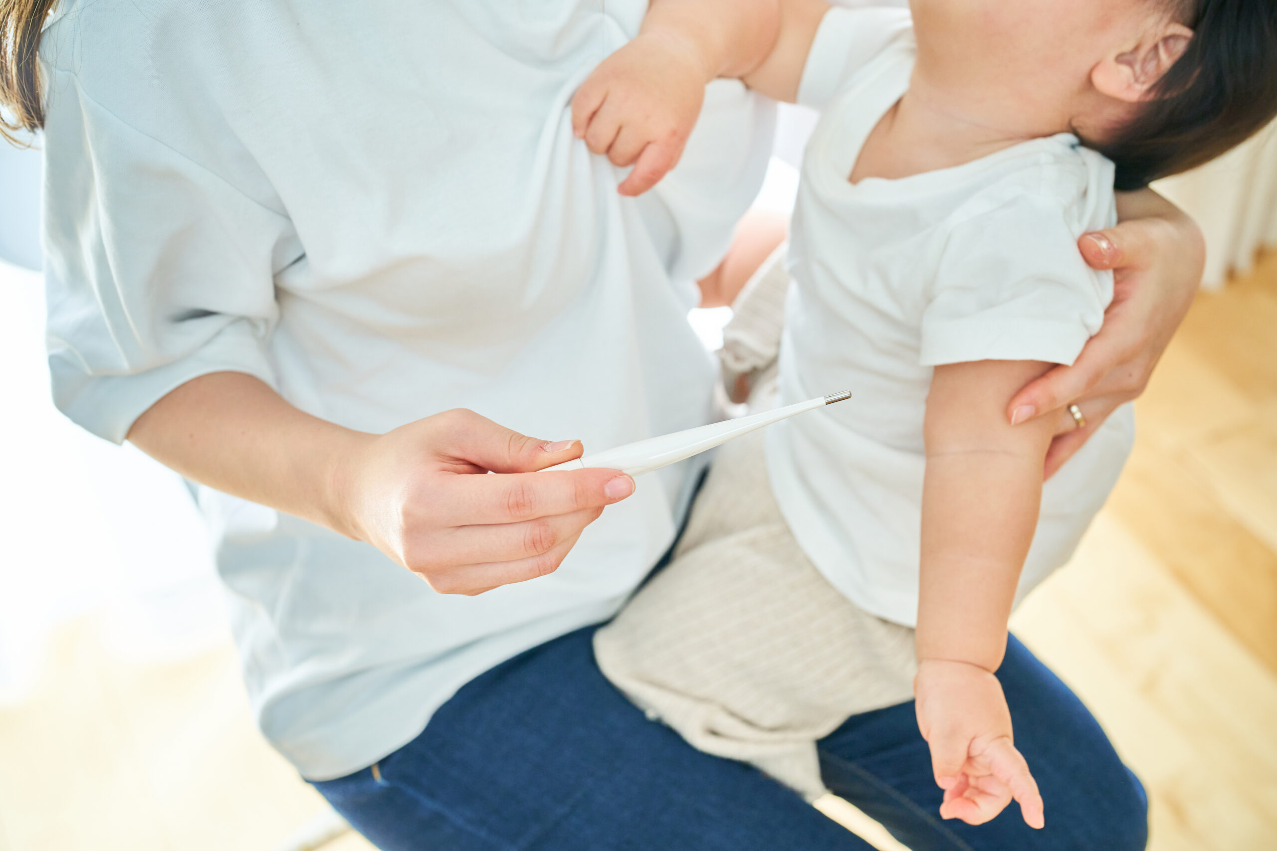 母親に体温を計測してもらう男の子